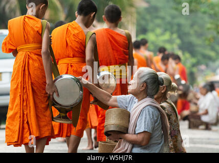 Laos Opfergaben zu buddhistischen Mönchen während traditionelle heilige Almosen Preisverleihung in Stadt Luang Prabang, Laos. Stockfoto