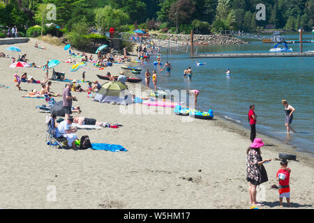 Sommer Spaß in Harrison Hot Springs. Beachgoers, Sonnenbaden und Spielen im Wasser am Harrison Lake. Stockfoto