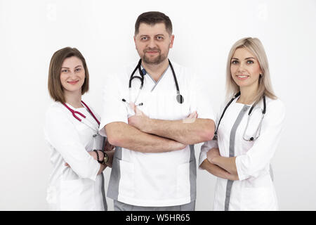 Ein junges Team von Ärzten mit stethoskope in einem modernen Uniform, ein Portrait gegen eine weiße Wand Stockfoto