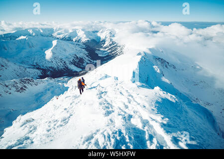Eine Gruppe von Bergsteigern aufsteigend ein Berg im Winter Stockfoto