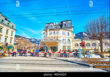 ZELL AM SEE, Österreich - 28. FEBRUAR 2019: Fußgänger sind an der Barriere der Bahnübergang im Grand Hotel warten, am 28. Februar in Zell am See Stockfoto