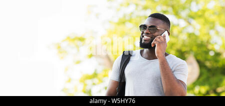 Portrait von stilvollen afrikanischen Mann in Sonnenbrille im Gespräch per Telefon Stockfoto