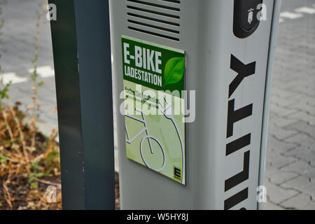 Wolfsburg, Deutschland, Juli 7., 2019: Ladesäule für eine elektrische Ladestation mit einem Anschluss zum Aufladen elektrische Fahrräder kostenlos Stockfoto