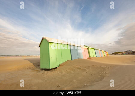 Strandhütten in Pastellfarben, geneigt aus dem Wind, an Berck-Plage, Pas-de-Calais, Frankreich Stockfoto