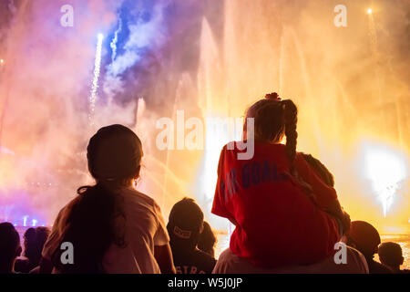 Orlando, Florida. Juli 13, 2019 kleine Mädchen beobachten Feuerwerk und Wasserstrahlen show in Seaworld Stockfoto