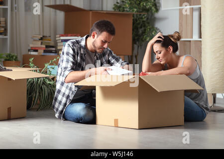 Traurig vertrieben Paar home Umzüge boxing Sachen sitzen auf dem Boden in der Nacht Stockfoto