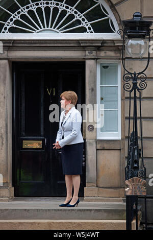 Bute House, Edinburgh, Schottland, Großbritannien. Juli 2019. Der erste Minister von Schottland Nicola Sturgeon am Eingang des Bute House erwartet Premierminister Boris Johnson bei seinem ersten Besuch nördlich der Grenze seit seinem Amtsantritt vor 5 Tagen. Stockfoto