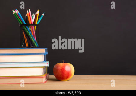 Büroartikel und frischen Apfel über kreidetafel Stockfoto