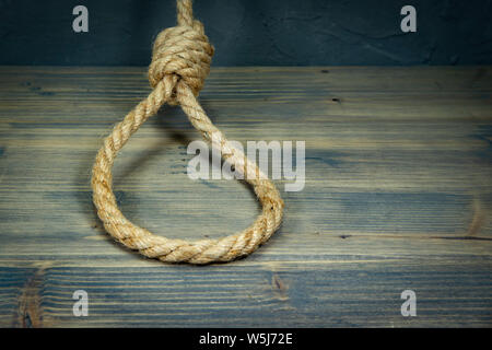 Der Henker Knoten auf einem rustikalen Holztisch in einem konzeptionellen Bild der Todesstrafe oder Selbstmord Stockfoto