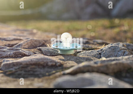 Nahaufnahme des Blau Baby Schnuller/Beruhigungssauger im Garten verloren - Bild Stockfoto