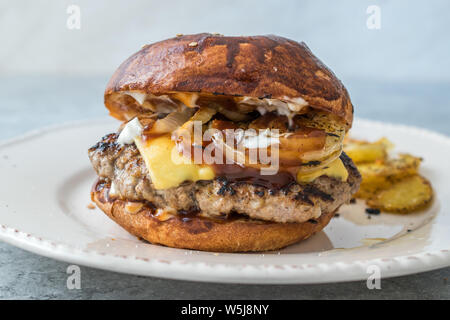 Hausgemachte Hamburger mit Cheddar Käse und karamellisierten Zwiebeln. Fast Food. Stockfoto