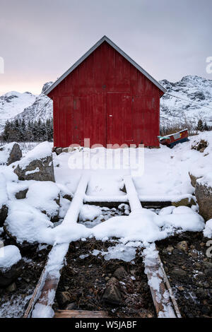Eine traditionelle norwegische Bootshaus mit Slipanlage in winterlichen und Schnee auf den Lofoten Inseln, Norwegen Stockfoto
