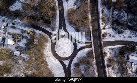 Luftaufnahme von einem roundabour durch Schneefall in einer kleinen walisischen Stadt umgeben Stockfoto