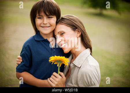 Junge seine Mutter eine Sonnenblume. Stockfoto