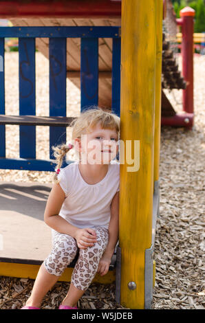 Schöne blonde Mädchen spielen auf dem Spielplatz Stockfoto