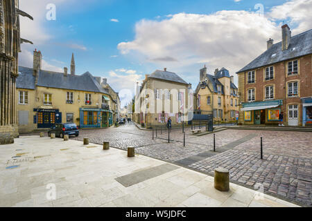 Geschäfte und Cafés entlang der malerischen öffentlichen Platz vor dem Eingang zum Bayeux Cathedral in der Normandie, Frankreich Stockfoto
