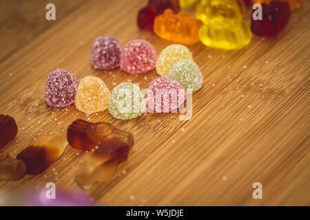 Ein Porträt von etwas Zucker beschichtete Spezialitäten auf einer hölzernen Tabelle angezeigt. Um die Stücke von Süßigkeiten gibt es etwas Zucker bestreut. Stockfoto