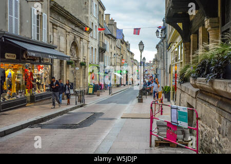 Touristen und lokalen französischen vorbei an Geschäften auf der Main Street, Rue Saint-Jean, durch die mittelalterliche Stadt von Bayeux, Frankreich. Stockfoto