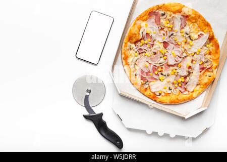 Frische Pizza in Karton und Smartphone mit leerer Bildschirm Stockfoto