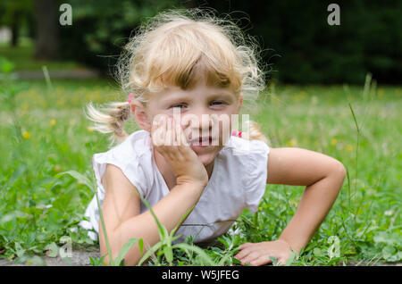 Schöne blonde Mädchen liegt auf der Wiese Stockfoto