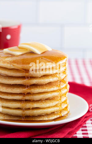 Stapel von frisch zubereiteten Pfannkuchen auf einem karierten Tischtuch Stockfoto