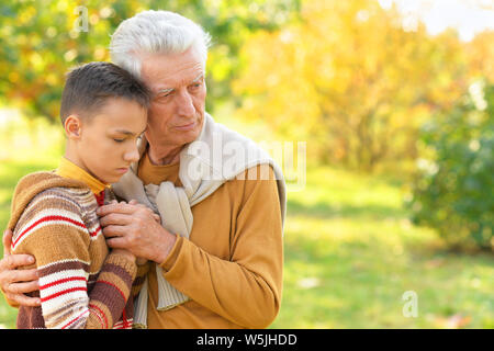 Portrait von traurigen Großvater und Enkel umarmen Stockfoto