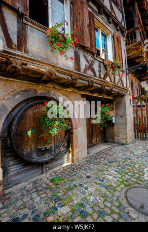 Alten Fachwerkhaus in der Gemeinde Bergheim, Elsass, Weinstraße, Frankreich, hölzerne Tor und Weinfass im Haus Fassade integriert Stockfoto