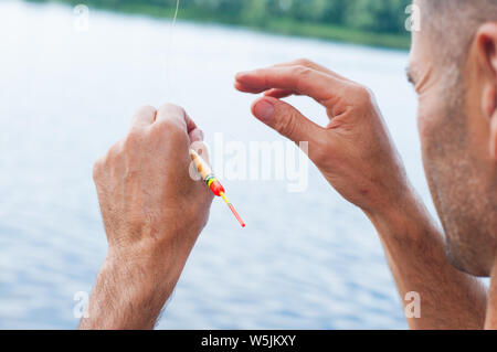 Man entwirren zu den verworrenen und geknoteten Angelschnur. Problemlösung. Stockfoto