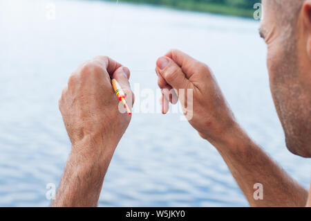 Man entwirren zu den verworrenen und geknoteten Angelschnur. Problemlösung. Stockfoto