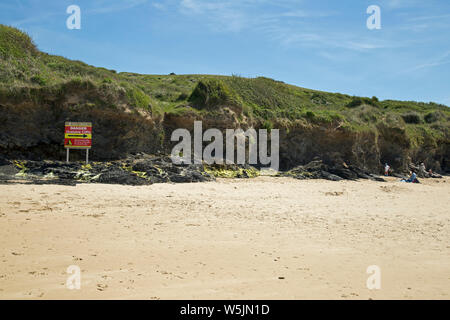 Cornwall, England, Mai 2019, ein Zeichen auf den Strand warnt Leute weg von den Klippen zu halten. Stockfoto