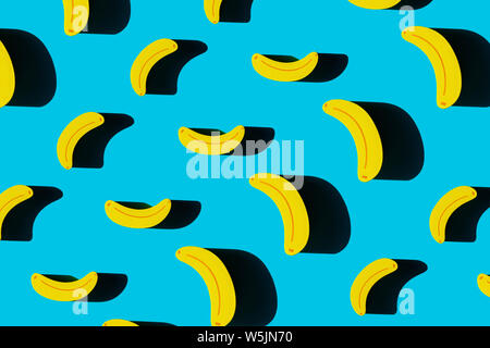 Bunte Obst Muster der gelben Holz- Bananen auf blauem Hintergrund. Ansicht von oben. Stockfoto