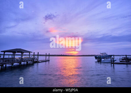 Wie der Sonnenuntergang verschwindet der Mond erscheint über masonboro Einlass in Wrightsville Beach, North Carolina. Stockfoto