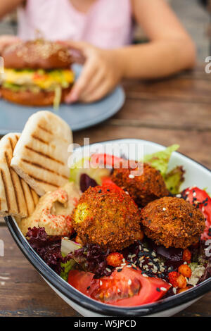 Israelische Street Food. Falafel mit Hummus, Rote-Bete-Salat und Gemüse in einer Schüssel in ein Restaurant. Stockfoto