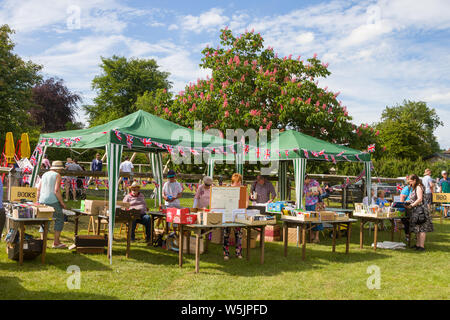 Buch vor einem roten Rosskastanie Baum abstirbt, Aesculus × Dryas, in der Blüte an einem traditionellen englischen Sommer fete in St. Leonard's, Buckinghamshire Stockfoto