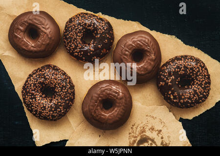 Blick von oben auf die leckere hausgemachte Schokolade Donuts auf der Verpackung Handwerk Papier Stockfoto