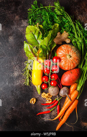 Herbst Gemüse Hintergrund. Kürbis, Zucchini, süsse Kartoffeln, Karotten und Rüben auf einem dunklen Hintergrund. Stockfoto