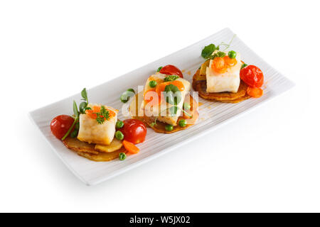 Fisch mit Gemüse auf weiße Platte. Auf weissem Hintergrund. Stockfoto