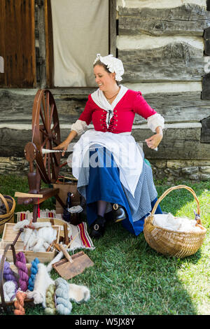 Eine reenactress betreibt ein spinnrad am historischen Alten Fort Wayne in Fort Wayne, Indiana, USA. Stockfoto