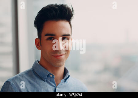 Junge männliche Portrait gegen Fenster Stockfoto