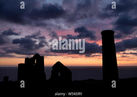 Silhouette von Wheal Coates aufgegeben Zinnmine in Cornwall, England nach Sonnenuntergang mit Laune und Briefmarken Engine House und Rauch, Stapel Stockfoto