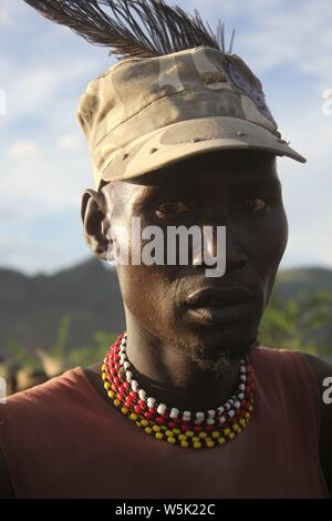 Ein junger Mann, der eine moderne Turkana Cap mit Straußenfedern oben eingefügt Stockfoto