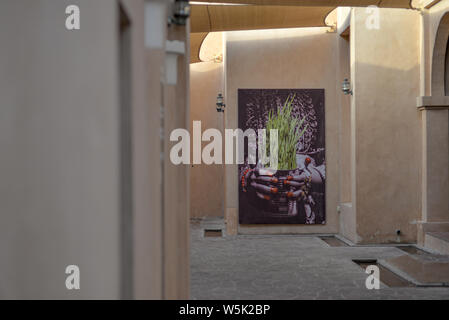 DOHA, Katar - 27. MAI 2016: Plakat von einem Blumentopf am Katara Cultural Village. Foto am Ende der Feder am Nachmittag. Stockfoto