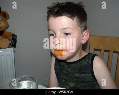 Junge herum und Grimassen, während er isst Spaghetti Bolognese Stockfoto