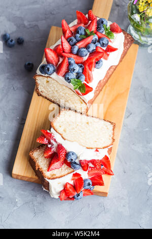 Sommer Dessert mit Erdbeeren und Blaubeeren. Buttercream berry Pound Cake mit Scheiben, bunten Früchte und Beeren auf der Oberseite, selektiver Fokus, Clos Stockfoto