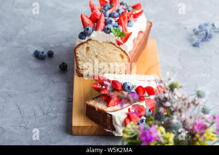 Sommer Dessert mit Erdbeeren und Blaubeeren. Buttercream berry Pound Cake mit Scheiben, bunten Früchte und Beeren auf der Oberseite, selektiver Fokus, Clos Stockfoto