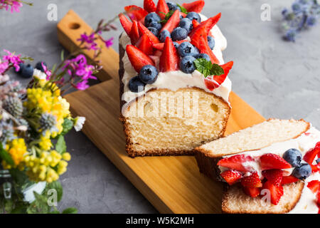 Sommer Dessert mit Erdbeeren und Blaubeeren. Buttercream berry Pound Cake mit Scheiben, bunten Früchte und Beeren auf der Oberseite, selektiver Fokus, Clos Stockfoto