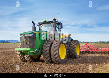 Sheffield, Canterbury, Neuseeland, 27. Juli 2019: Ein großes, modernes, John Deere Traktor schleppt eine Bodenfräse, in einem Feld im Winter Stockfoto