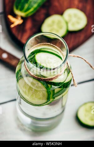 Infundiert Wasser mit in Scheiben geschnittenen Gurken in der Flasche Stockfoto