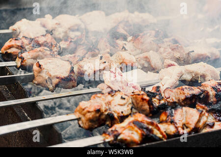 Nahaufnahme von appetitlich heißen Shish Kebab auf Metall Spieße bereitet auf den Kohlen im Freien. Grillen schaschlik am Grill zubereitet. Stockfoto