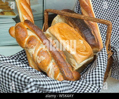 Brotkorb mit Artisan Brot und ein blau kariertem Tuch Stockfoto